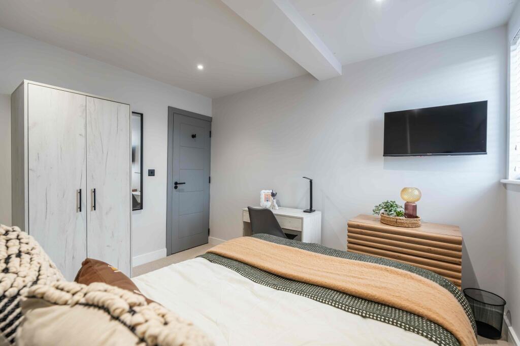 Bright and modern master bedroom featuring a la...