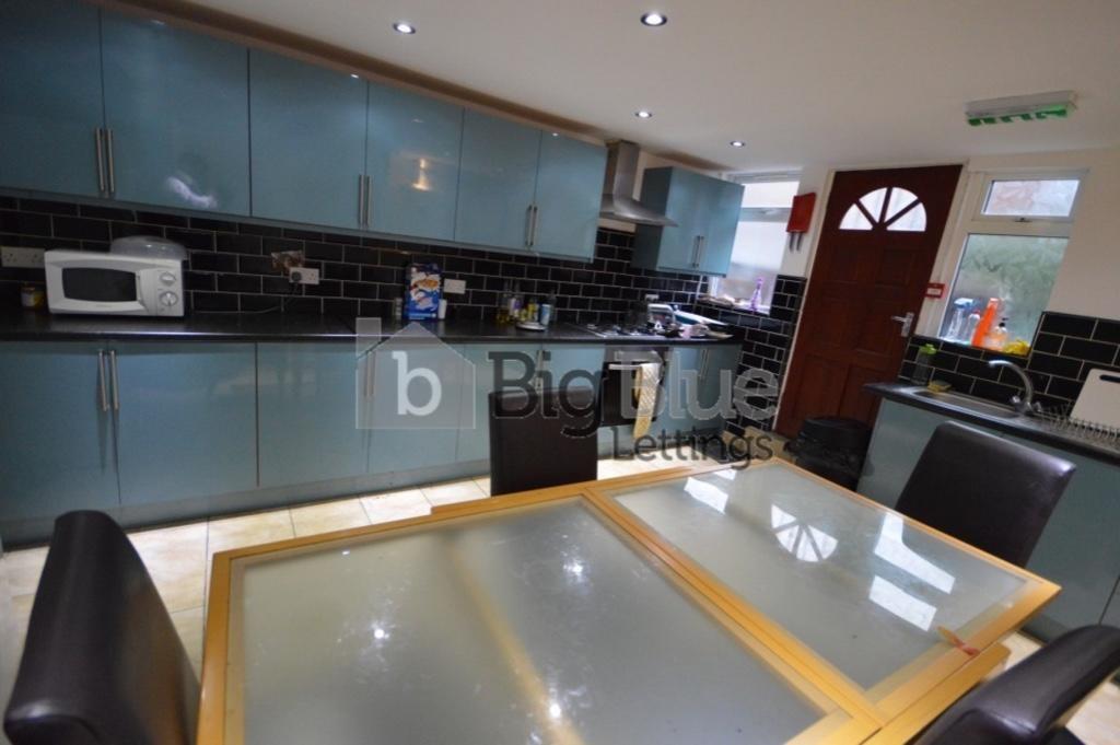 Modern kitchen featuring sleek cabinetry, a gla...
