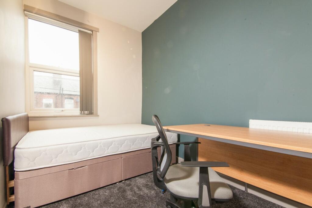 A bright and spacious double bedroom with a coz...