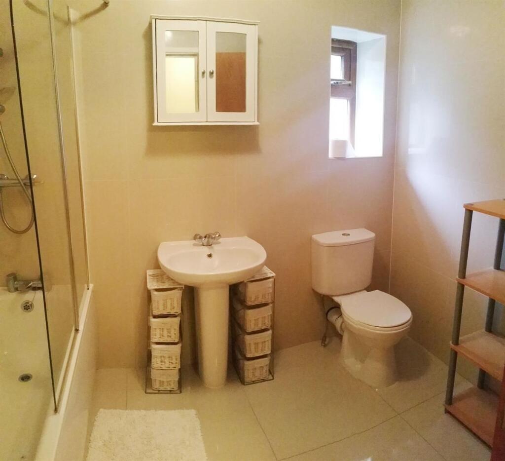 Bright, neutral bathroom with a pedestal sink, ...