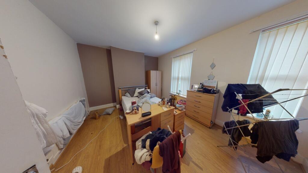 A bright double bedroom featuring wooden floori...