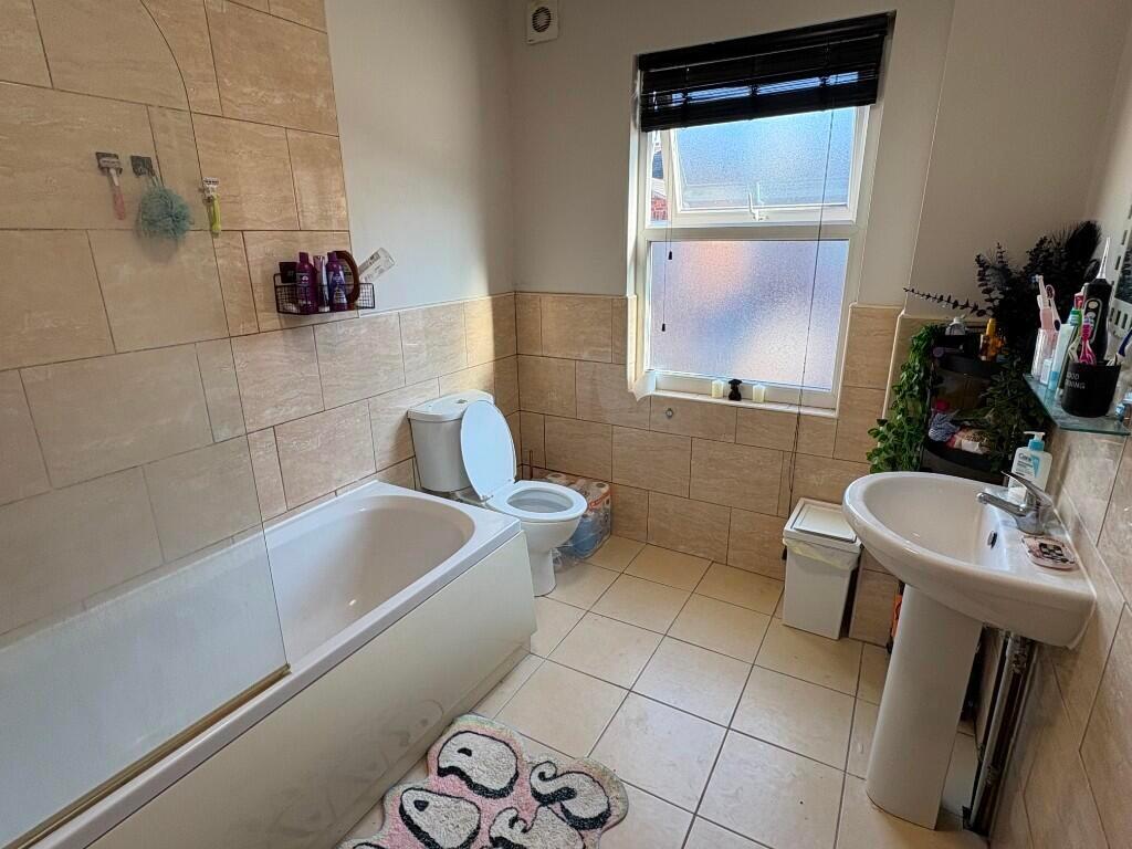 Bright and clean bathroom featuring a bathtub, ...