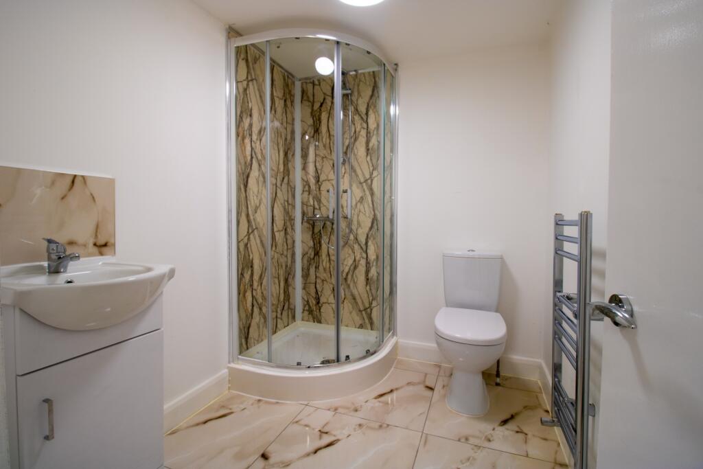 Modern bathroom featuring a spacious shower enc...