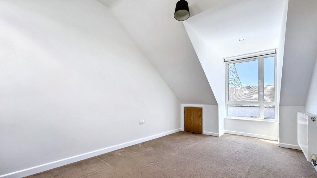 Bright and airy bedroom with a large window pro...
