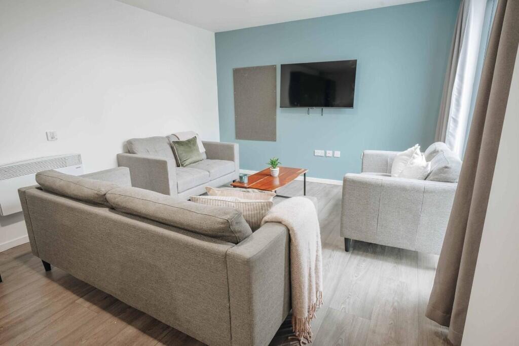 A modern living room featuring neutral-toned so...