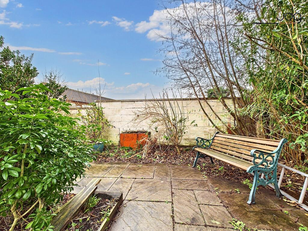 Tiered rear garden with pond and seating area