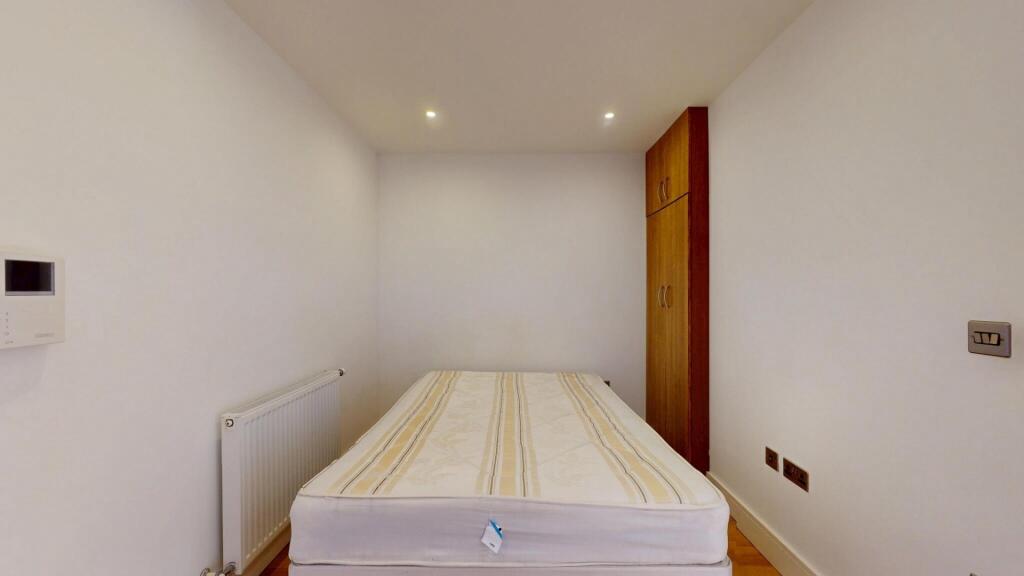 A bright and clean single bedroom featuring a l...