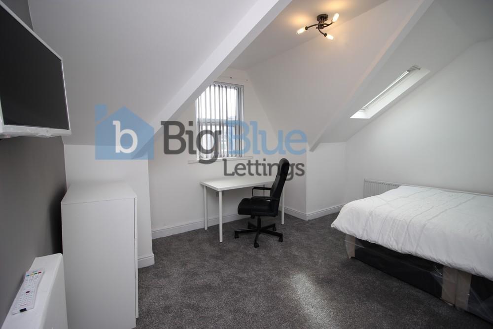 A neat and well-kept single bedroom featuring a...