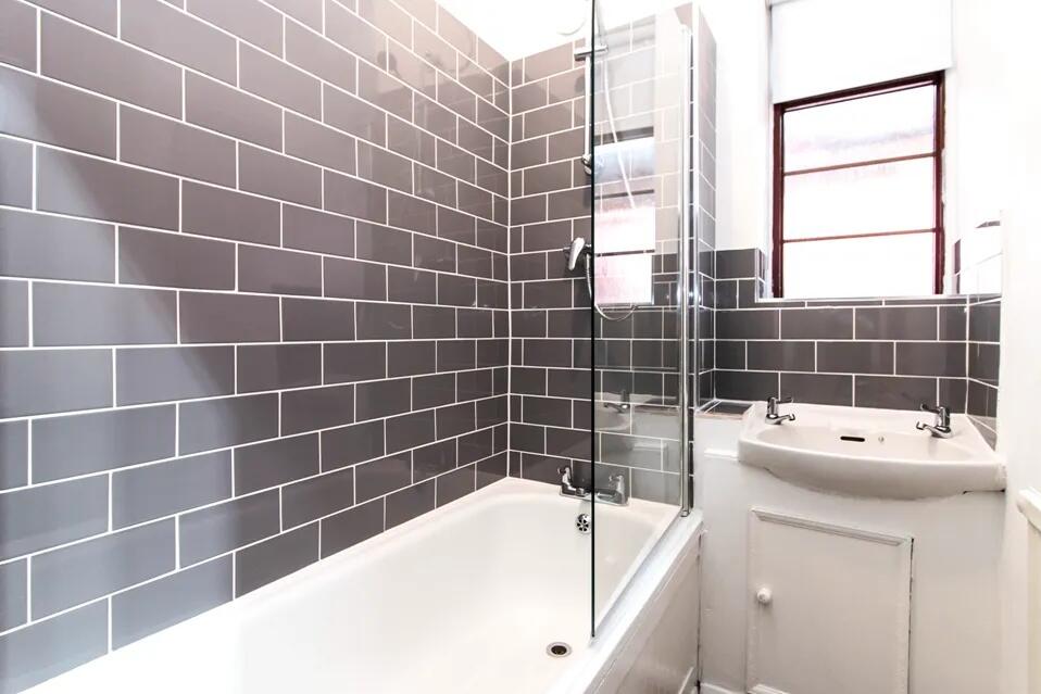 Bright and modern bathroom suite featuring a cl...