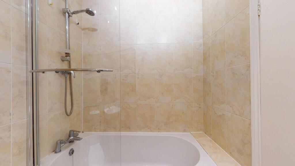 A clean and spacious bathroom with a large bath...