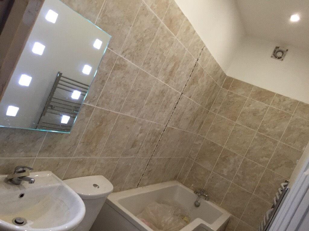 A modern bathroom featuring beige tiled walls a...