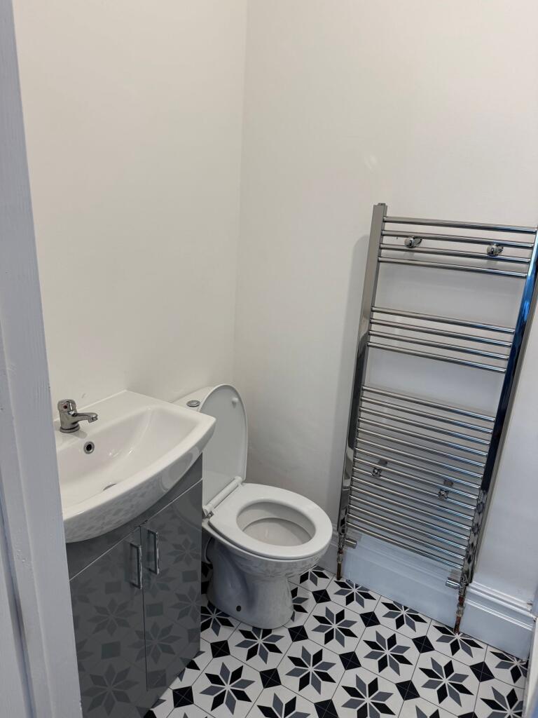 A clean and modern single toilet room featuring...