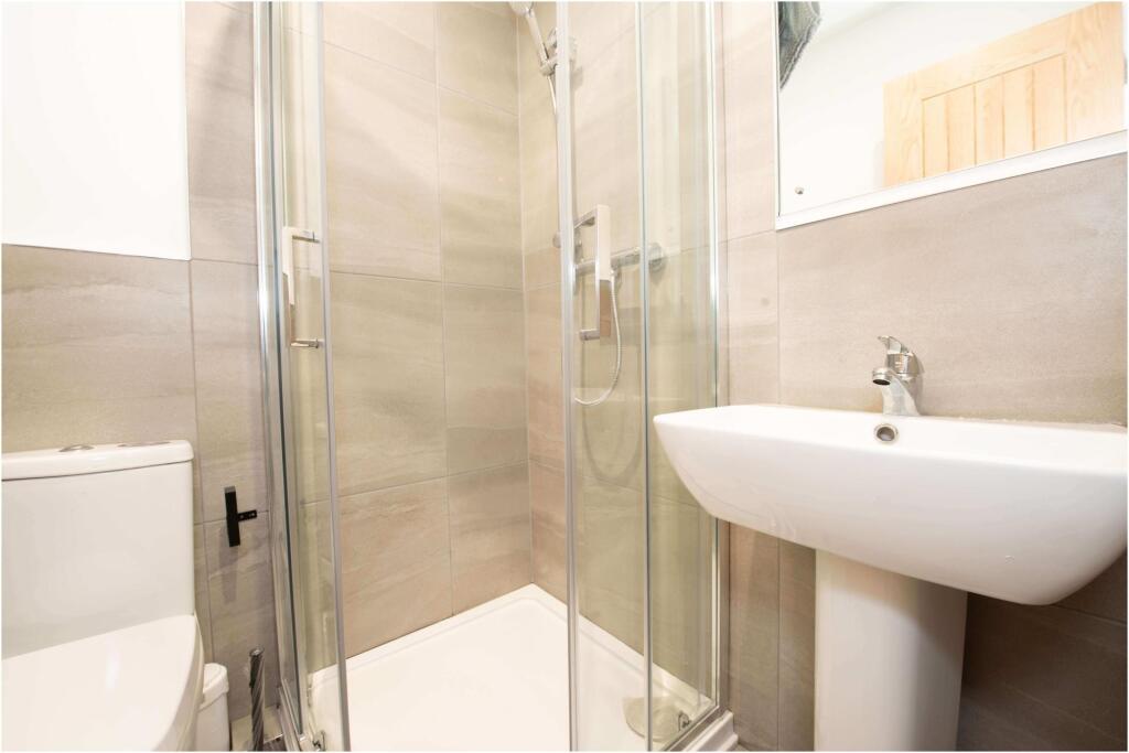 A clean and modern bathroom with a shower, a to...