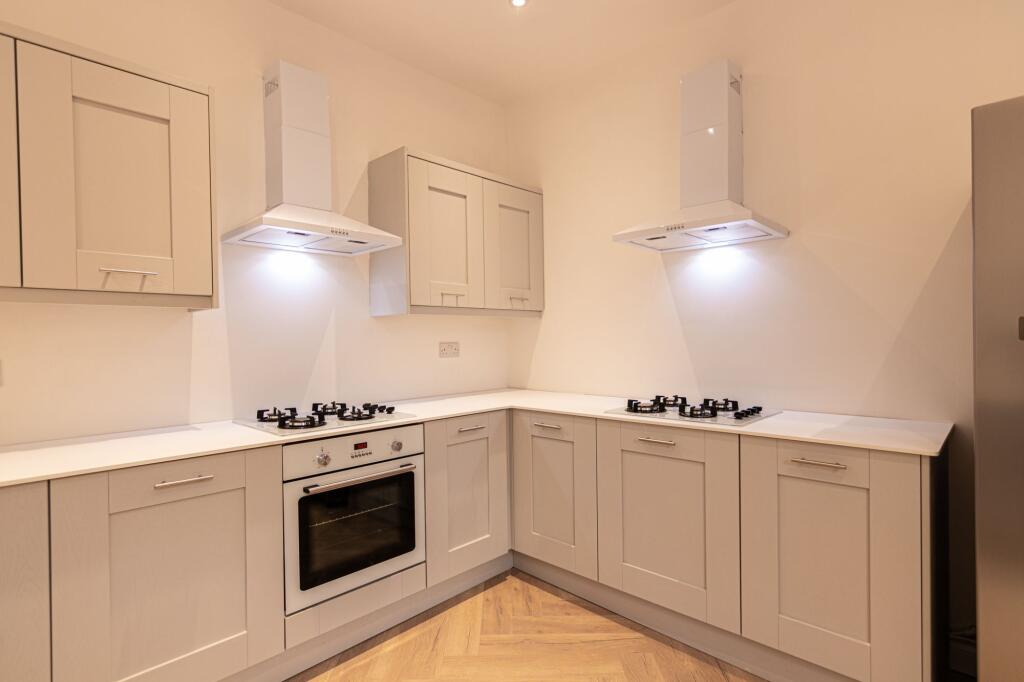 Bright and modern kitchen featuring cream cabin...
