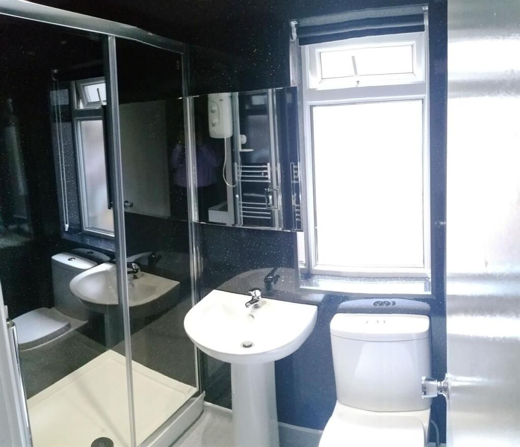 Bright, modern bathroom with a pedestal sink, t...