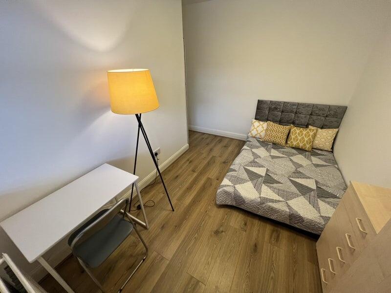 A cozy single bedroom featuring a modern, patte...