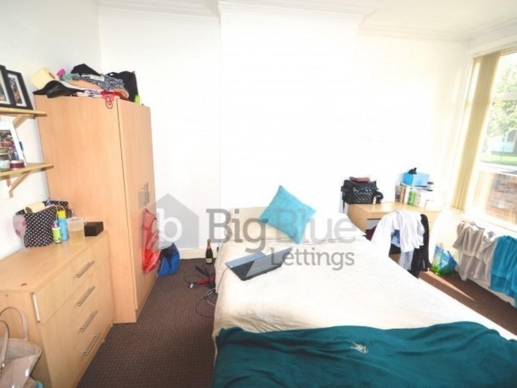 A bright double bedroom featuring a large windo...
