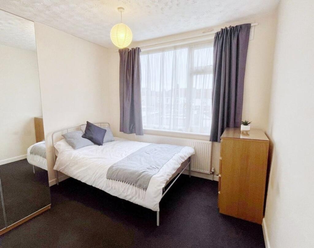 This inviting double bedroom features a comfort...