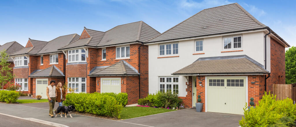 Modern suburban houses with red brick and white exteriors, greenery, and a couple walking their dog