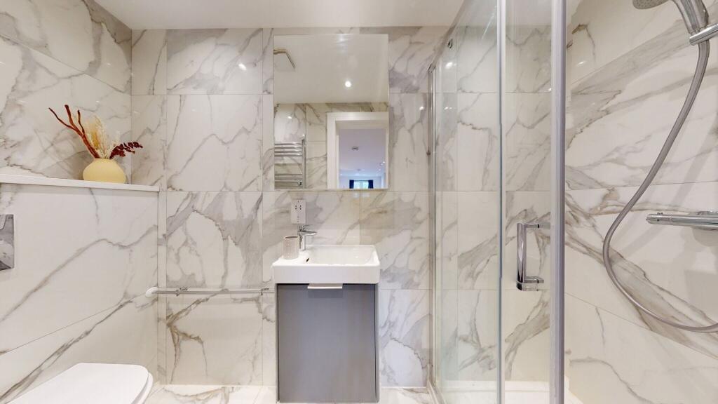 A modern bathroom clad in elegant marble-effect...