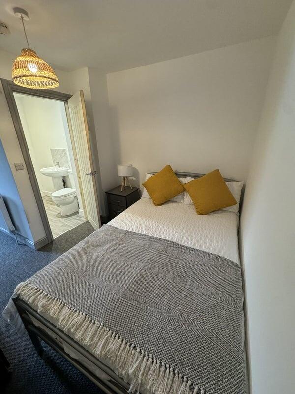 Cozy double bedroom featuring a neatly made bed...