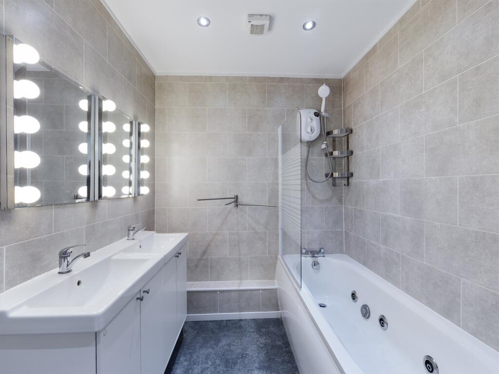 A spacious and modern bathroom featuring a luxu...