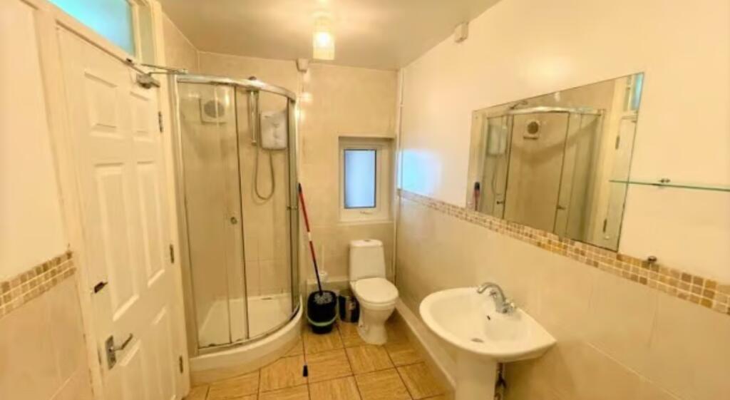 Bright and clean bathroom featuring a corner sh...