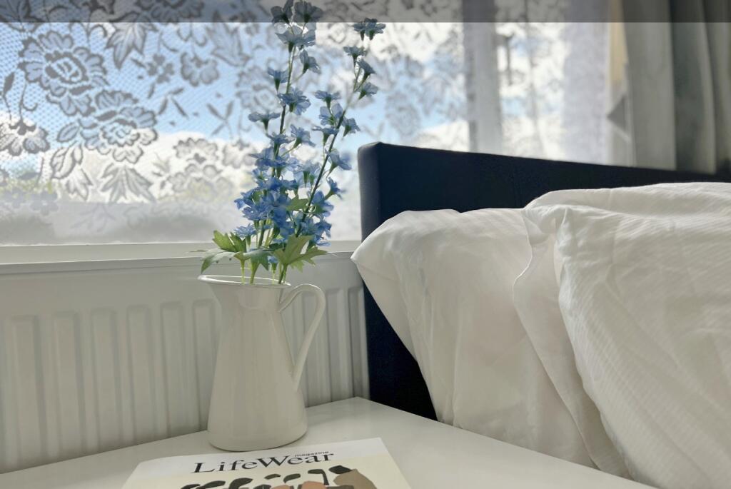 A serene bedroom corner featuring a neatly made...