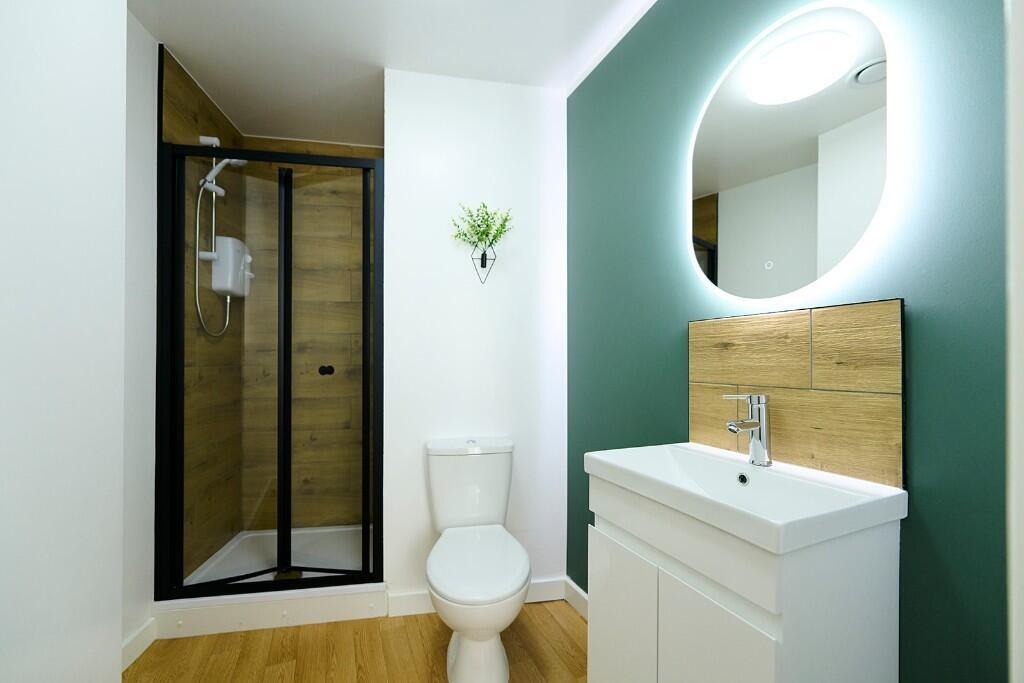 A modern bathroom suite featuring a sleek walk-...