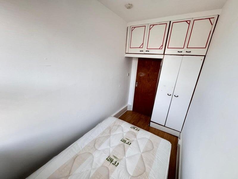 A compact single bedroom with a clean wooden fl...