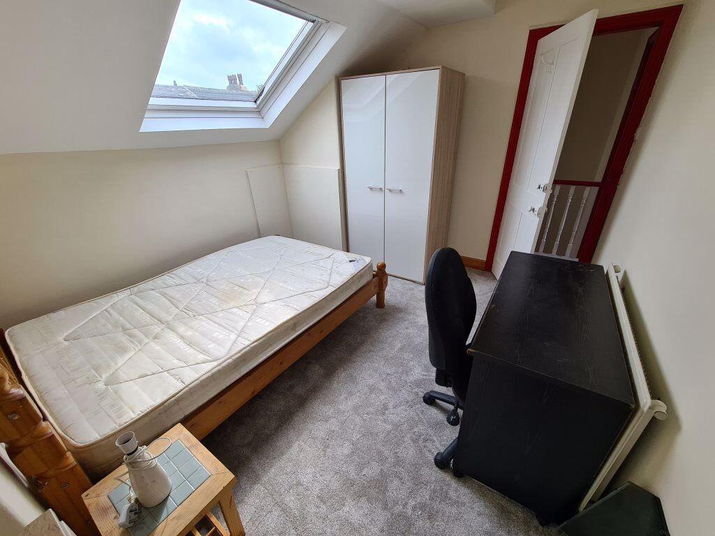 Cozy single bedroom featuring a large skylight ...