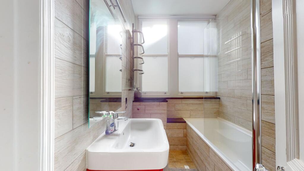 Bright and modern bathroom suite featuring a fu...