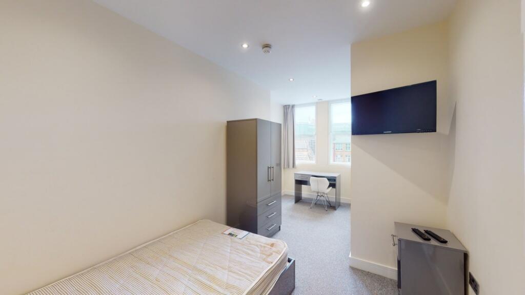 A neatly arranged single bedroom featuring a co...