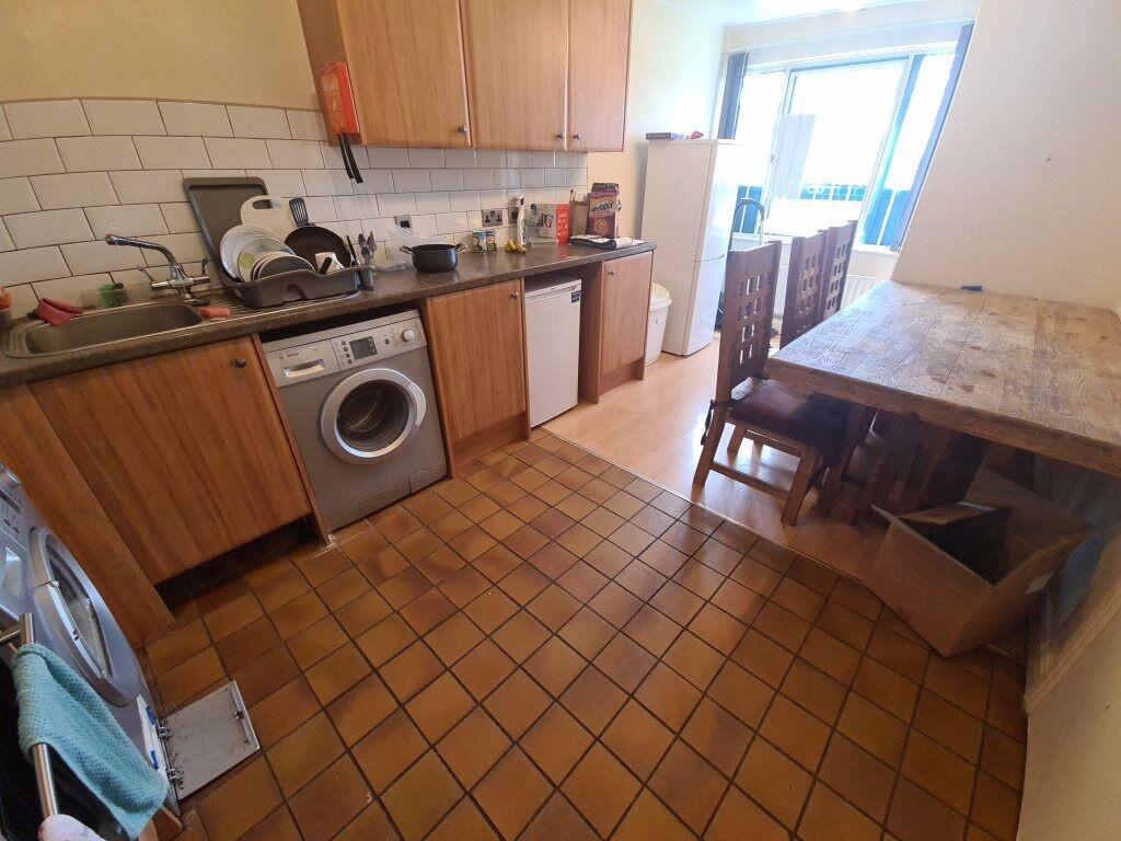 Functional kitchen with tiled floor, wooden cab...