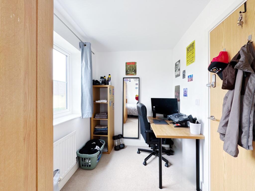 A cozy student bedroom featuring a workspace wi...