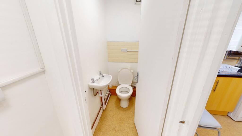A tidy single toilet with essential amenities, ...