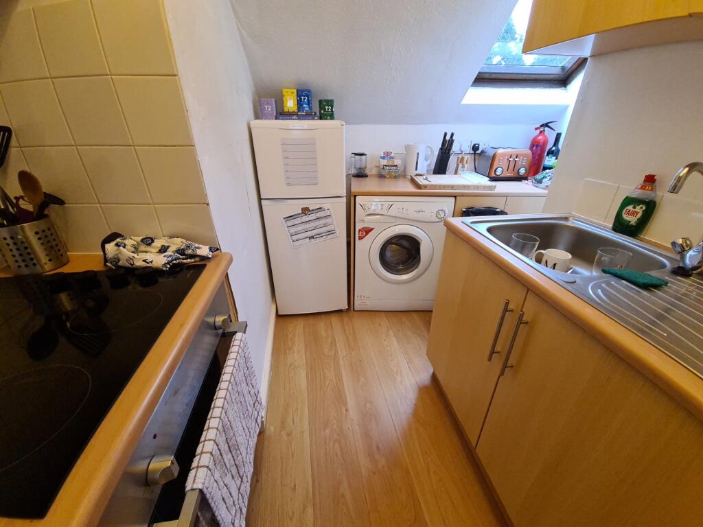 Compact fitted kitchen with wood-effect worktop...