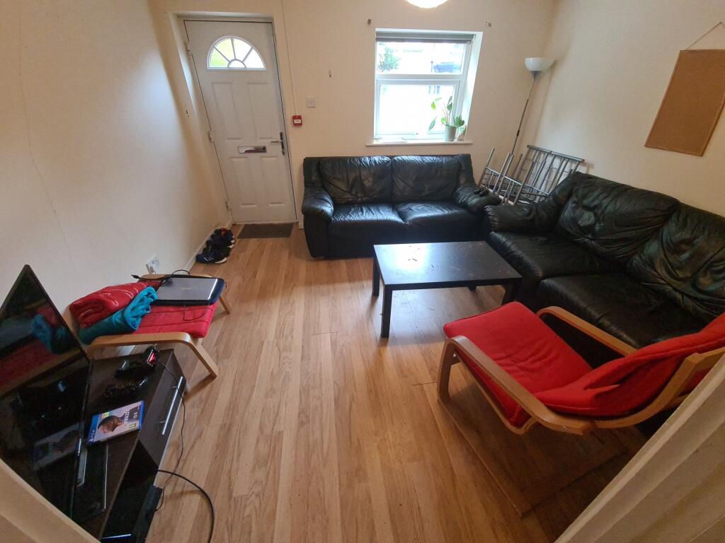 Cozy living room with wooden flooring, a comfor...