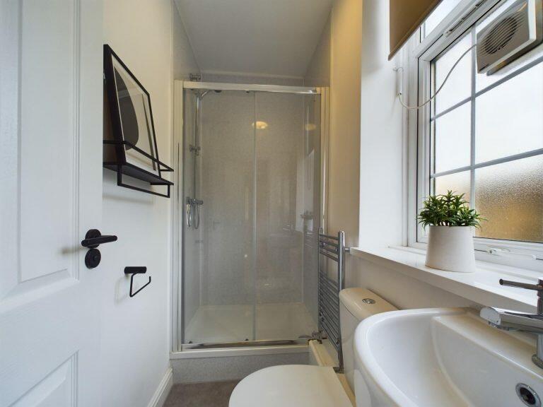 A modern and pristine bathroom featuring a glas...