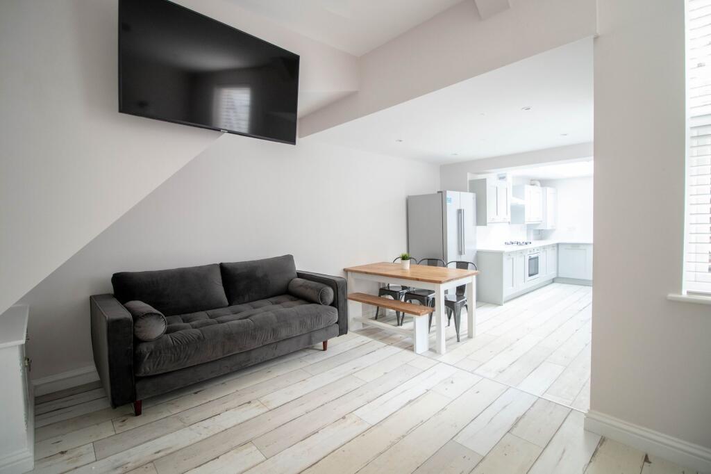A modern, spacious living room with a large fla...