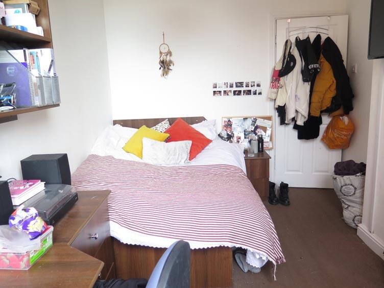 A cozy student bedroom featuring a double bed w...