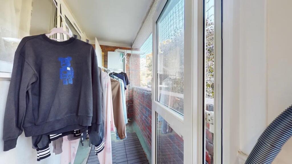 A bright enclosed balcony area with ample natur...