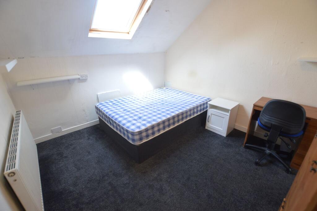 Cozy double bedroom with a large skylight provi...