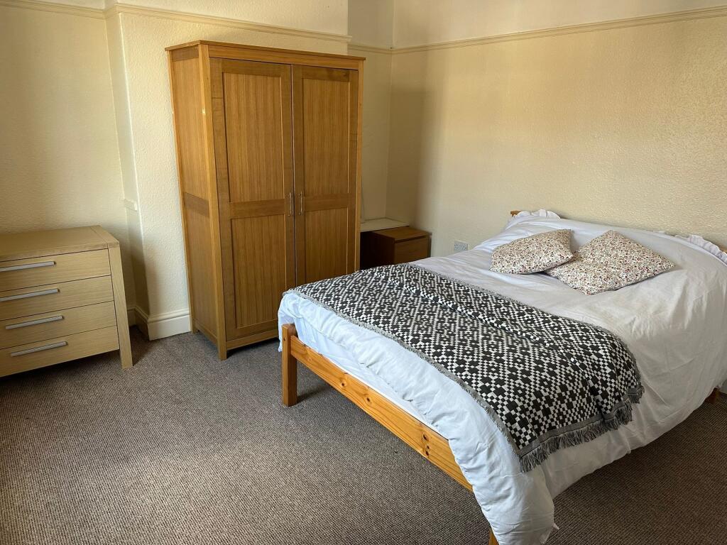 A bright and inviting double bedroom with a woo...