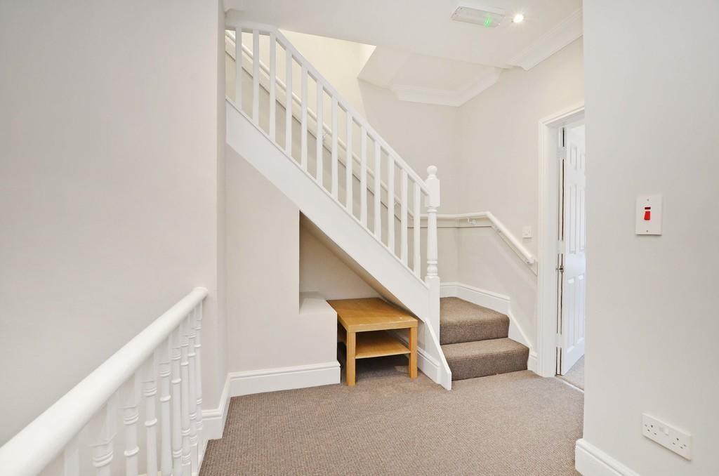 A clean and bright hallway area featuring a whi...