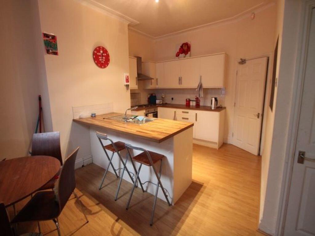 Bright and tidy kitchen with a wooden breakfast...