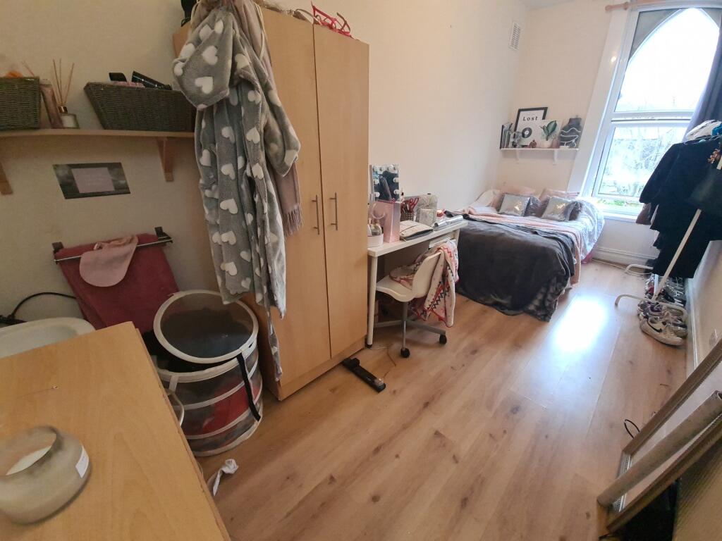 A cozy and well-lit single bedroom featuring a ...