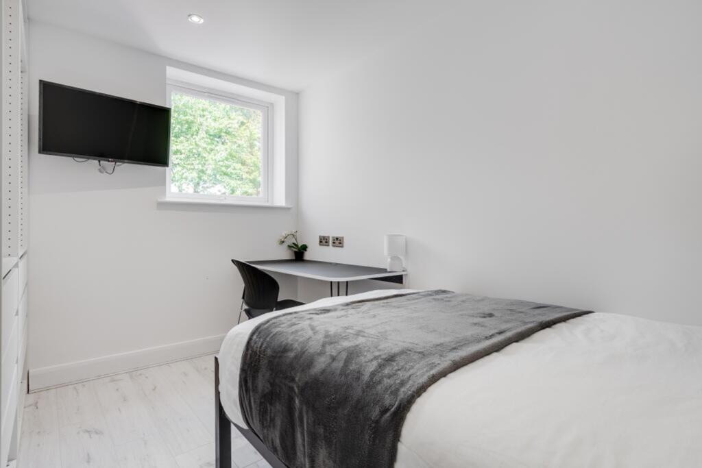 A bright and tidy double bedroom featuring mode...