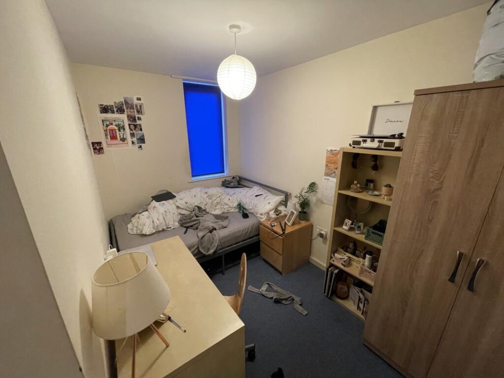 Cozy single bedroom featuring a well-organized ...