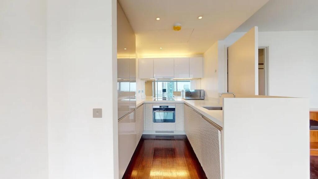 Bright and modern kitchen featuring sleek white...